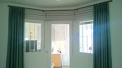 Bay window with Roman blinds & pinchpleat curtains